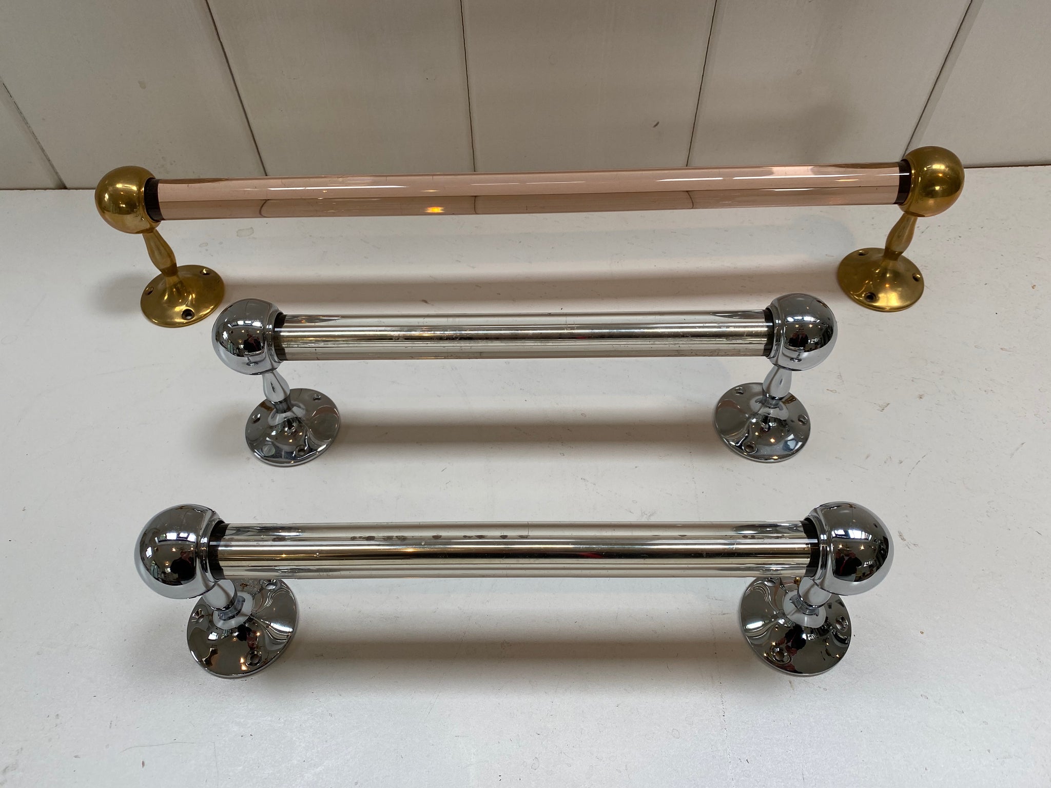 a peach glass towel rail and a pair of silver mirrored grab handles c.1920