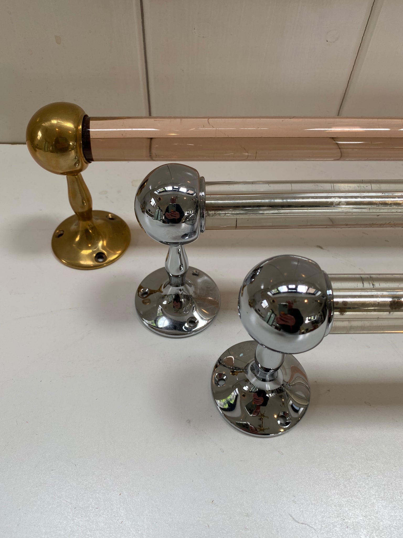 a peach glass towel rail and a pair of silver mirrored grab handles c.1920