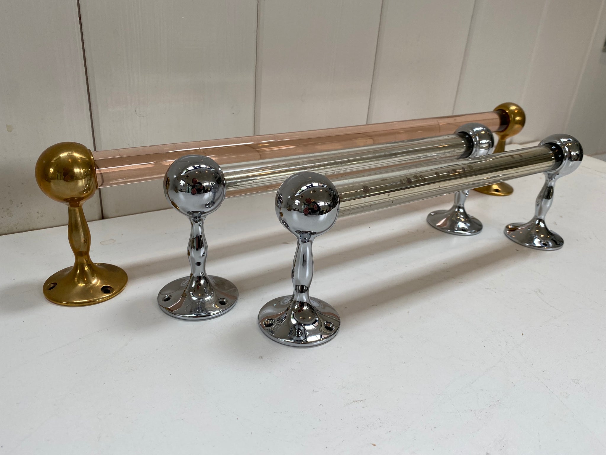 a peach glass towel rail and a pair of silver mirrored grab handles c.1920